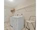 Bright laundry room with washer, dryer, and overhead shelving at 26071 Paysandu Dr, Punta Gorda, FL 33983