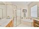 Bright bathroom with a glass-enclosed shower, a soaking tub, and a vanity area at 2925 122Nd E Pl, Parrish, FL 34219