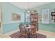 Cozy dining room features a round table, four chairs, and a beautiful cabinet with decor at 2925 122Nd E Pl, Parrish, FL 34219