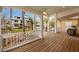 Relaxing front porch with wood flooring, white railings, and tropical views at 306 55Th St, Holmes Beach, FL 34217