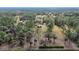 Aerial view showing a house on a spacious lot with surrounding trees and pasture at 3340 Ulman Ave, North Port, FL 34286