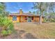 House exterior featuring a yellow facade, green door, and a cozy front porch at 3340 Ulman Ave, North Port, FL 34286