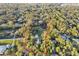 Aerial view showing the home, property lines, pond, and surrounding lush trees at 3501 Sunbeam Dr, Sarasota, FL 34240