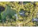 Aerial view of the house nestled among trees, featuring a pool, pond, and a long driveway at 3501 Sunbeam Dr, Sarasota, FL 34240