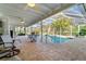 Screened-in pool area with tiled flooring, ceiling fans, and outdoor seating at 3501 Sunbeam Dr, Sarasota, FL 34240