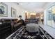 Bright living room with leather sofas, ottoman, and view of kitchen and patio at 3716 Eagle Hammock Dr, Sarasota, FL 34240