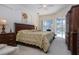 King-size bed, dark wood furniture, and access to backyard pool at 3716 Eagle Hammock Dr, Sarasota, FL 34240