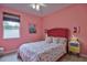 Bedroom with pink walls, floral bedding, and a red headboard at 3906 Chaucer Ln, Sarasota, FL 34241