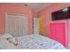 Bedroom with pink walls, floral bedding, and a pink dresser at 3906 Chaucer Ln, Sarasota, FL 34241