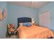 Bright bedroom with orange bedding, a blue chair, and double doors at 3906 Chaucer Ln, Sarasota, FL 34241