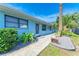 Light blue house exterior, featuring walkway, landscaping, and palm tree at 401 Shore Rd, Nokomis, FL 34275