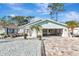 Front view of a charming ranch house with a light teal roof and white brick facade at 4534 Pike Ave, Sarasota, FL 34233