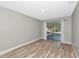 Living room with wood-look floors, sliding doors to patio, and white curtains at 4534 Pike Ave, Sarasota, FL 34233