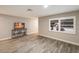 Living area with wood-look floors, TV, and window with white shutters at 4534 Pike Ave, Sarasota, FL 34233