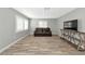 Bright living room with wood-look floors, large windows, and a brown leather couch at 4534 Pike Ave, Sarasota, FL 34233