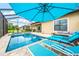 Screened pool and spa with lounge chairs and umbrella at 4653 Royal Dornoch Cir, Bradenton, FL 34211