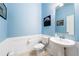 Stylish powder room with pedestal sink and light blue walls at 4653 Royal Dornoch Cir, Bradenton, FL 34211