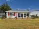 White house with red accents, patio furniture and landscaping at 4714 Potomac Cir, Bradenton, FL 34210