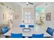 Elegant dining room with white table and blue chairs, view of entryway at 4821 Hanging Moss Ln, Sarasota, FL 34238