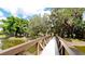 Scenic footbridge leading through a lush, tree-lined walkway at 4821 Hanging Moss Ln, Sarasota, FL 34238