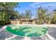 Curved pool with surrounding patio and lush landscaping at 4857 Primrose Path, Sarasota, FL 34242