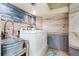 Laundry room with farmhouse sink, washer, dryer, and wood walls at 541 Edlee Ln, Longboat Key, FL 34228