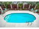 Inviting kidney-shaped pool with surrounding patio and lounge chairs at 541 Edlee Ln, Longboat Key, FL 34228