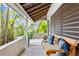 Relaxing covered porch with wooden bench and tropical plants at 541 Edlee Ln, Longboat Key, FL 34228