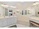 Spacious bathroom with double sinks, corner bathtub, and floral wallpaper at 5532 Country Club Way, Sarasota, FL 34243