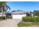 Single-Gathering home with a white garage door and landscaping at 5532 Country Club Way, Sarasota, FL 34243