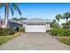 Exterior view of the house, highlighting the white garage door and landscaping at 5532 Country Club Way, Sarasota, FL 34243