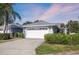 House exterior featuring a white garage door, landscaping, and a paved driveway at 5532 Country Club Way, Sarasota, FL 34243