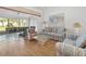 Living room with patterned sofas, a glass-top coffee table, and hardwood floors at 5532 Country Club Way, Sarasota, FL 34243