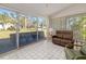 Bright sunroom with tiled floor, comfy seating, and sliding glass doors opening to a view of the backyard at 5532 Country Club Way, Sarasota, FL 34243