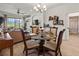 Dining area with glass top table and four chairs, view to living room and bath at 5715 Spanish Point Ct, Palmetto, FL 34221