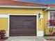 Brown garage door with house number 5715 on a yellow house at 5715 Spanish Point Ct, Palmetto, FL 34221