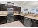 Modern kitchen with dark cabinetry, stainless steel appliances, and light countertops at 5715 Spanish Point Ct, Palmetto, FL 34221