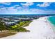 Aerial view showcasing Gulf Bay Club's location on the beach with white sand and turquoise water at 5780 Midnight Pass Rd # 609, Sarasota, FL 34242