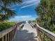 Wooden boardwalk with benches leads to the beach at 5780 Midnight Pass Rd # 609, Sarasota, FL 34242