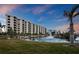 Exterior view of building with pond and fountain at sunset at 5780 Midnight Pass Rd # 609, Sarasota, FL 34242