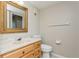 Bathroom with light wood vanity, toilet, and a framed mirror at 618 Bird Bay S Dr # 206, Venice, FL 34285