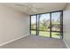 Bedroom with carpeted floor, ceiling fan, and large window with a garden view at 618 Bird Bay S Dr # 206, Venice, FL 34285