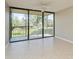 Living room with tile floors and sliding doors leading to a balcony at 618 Bird Bay S Dr # 206, Venice, FL 34285