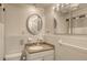 Clean bathroom with white tiled walls and a granite vanity at 6750 Gulf Of Mexico Dr # 153, Longboat Key, FL 34228