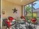 Relaxing screened porch with wicker furniture and red pillows at 6819 Grand Estuary Trl # 102, Bradenton, FL 34212