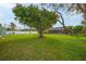 Large backyard featuring a sprawling tree and screened patio at 7510 16Th Nw Ave, Bradenton, FL 34209