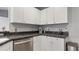 White cabinets and stainless steel dishwasher in this kitchen at 7664 39Th Street E Cir, Sarasota, FL 34243