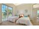 Bright bedroom with twin beds, balcony access, and tile floors at 777 N Manasota Key Rd, Englewood, FL 34223