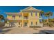 Two-story yellow beach house with balcony at 777 N Manasota Key Rd, Englewood, FL 34223