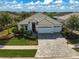 Beautiful home shows off its manicured front yard, a paver driveway and swaying palm trees at 8261 Grande Shores Dr, Sarasota, FL 34240